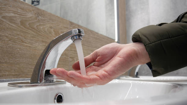 close-up of a man's hand under a running tap - well fountain water pipe pipe imagens e fotografias de stock