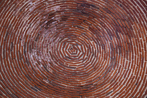 Brick wall with a round window in the middle