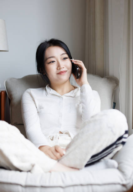 istock Young women sitting on the sofa making phone calls 1814424431