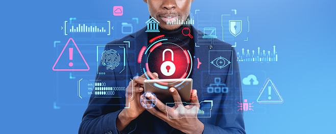 Unrecognizable African businessman using tablet with double exposure of immersive padlock cybersecurity interface and computer virus alert icons over blue background. Data protection concept