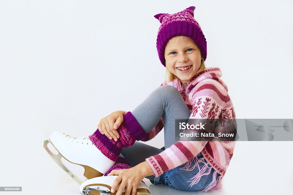 cheerful girl sitting on ice skates Cute girl sitting on ice skates Activity Stock Photo
