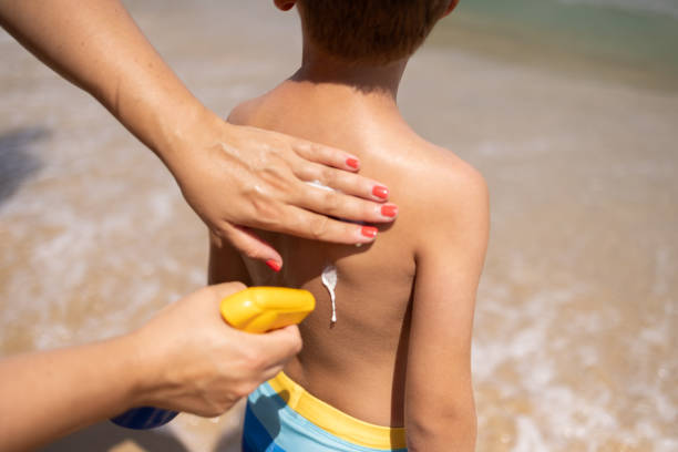 istock Mother applying a sunscreen lotion on her son's back, at the beach 1814451077