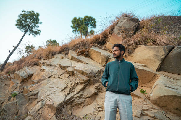 istock Young man looks at the sunset view standing in the mountains. 1814455379