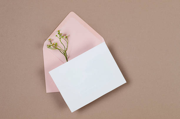 istock Pink envelope with empty white card for text on beige background 1814473284