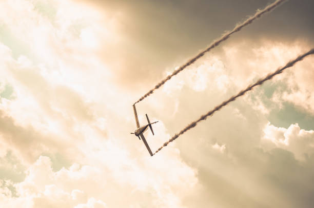 flugzeug hinterlässt rauch und fliegt bei sonnenuntergang gegen den himmel - vapor trail sky night sunset stock-fotos und bilder