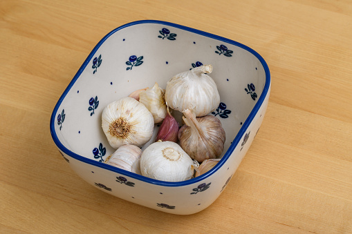 Natural antibiotic garlic, whole heads placed in a bowl closeup