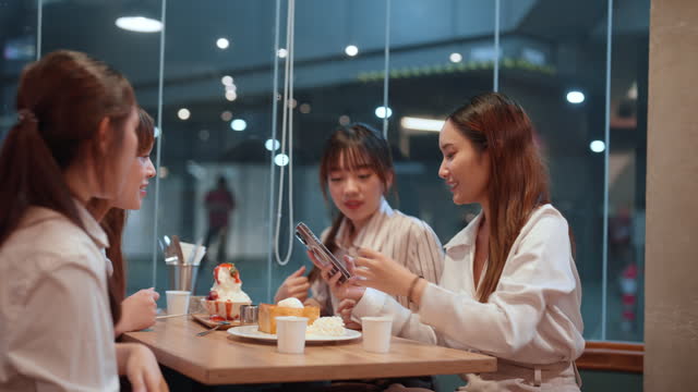 A Group of Young Asian Women Taking a Selfie Together with Desserts Before Eating to Capture a Memorable Moment.