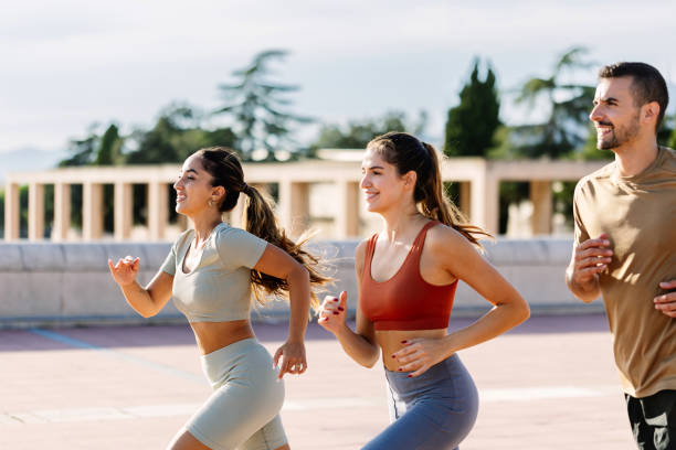 Three young friends running together outdoors.
