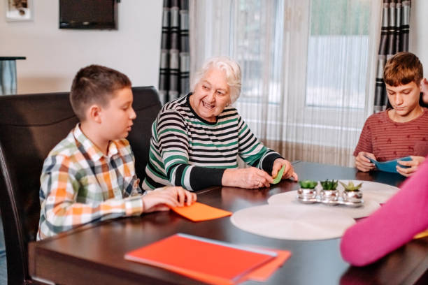 istock Multi-Generation Family members having fun at home making origami using paper sheet 1814510772