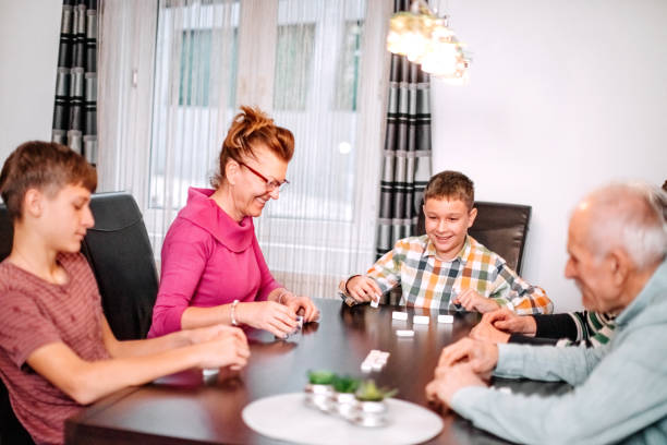 istock Multi-Generation Family members having fun at home with playing dominoes 1814511286