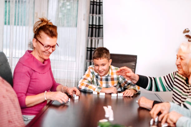 istock Multi-Generation Family members having fun at home with playing dominoes 1814511287