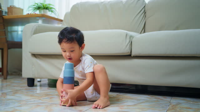 Baby boy Playing With Plastic Stacking Cups at home