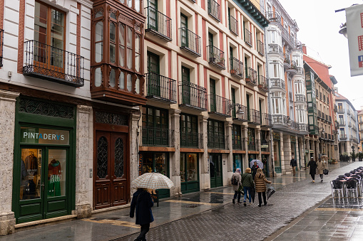 Valladolid, Spain, Oct. 27, 2023: rainy day with people walking under umbrellas in the old city of Valladolid, Spain