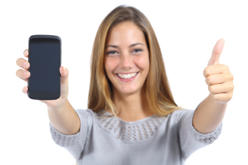 Beautiful woman showing a smartphone with thumb up isolated on a white background