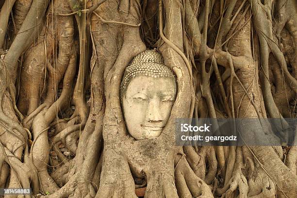 Stone Budda Traped En Árboles De Raíces At Wat Mahathat Foto de stock y más banco de imágenes de Antiguo