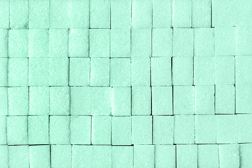Flat lay pieces of sugar toned in the color neo mint, background.