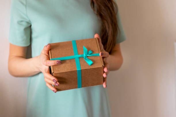 крупный план женщины, держащей завернутую подарочную коробку. праздник - tiffany box стоковые фото и изображения
