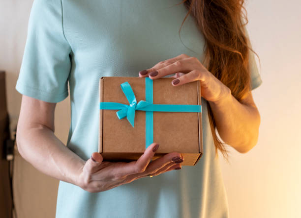 крупный план женщины, держащей завернутую подарочную коробку. праздник - tiffany box стоковые фото и изображения