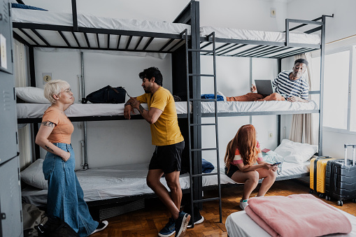 Friends talking in bedroom at hostel