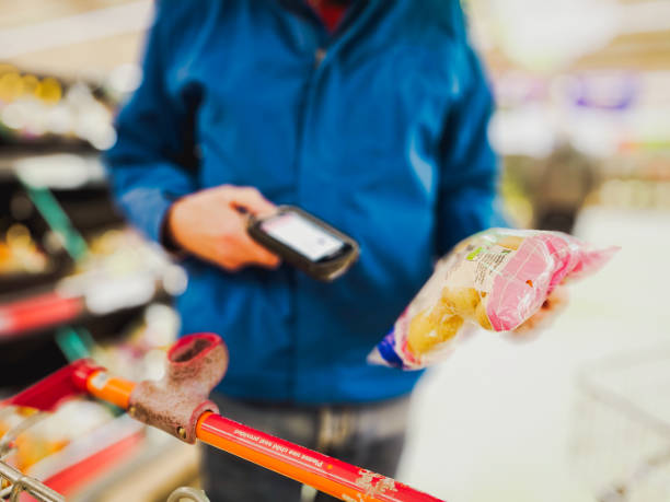 istock Man holding bar code scanner and scanning products in store 1814675010