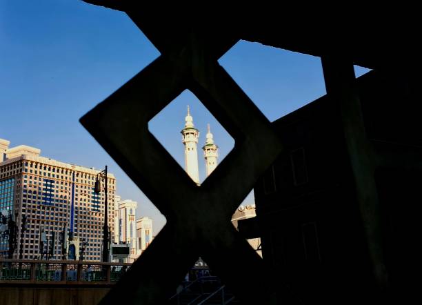 A view of two high minarets of the Great Mosque of Makkah in the perspective of the ornamental fence in the morning.