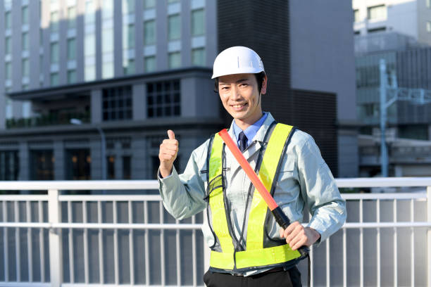 야외에서 가이드 로드를 들고 엄지손가락을 치켜세우는 젊은 아시아 남성 노동자 - flagger 뉴스 사진 이미지
