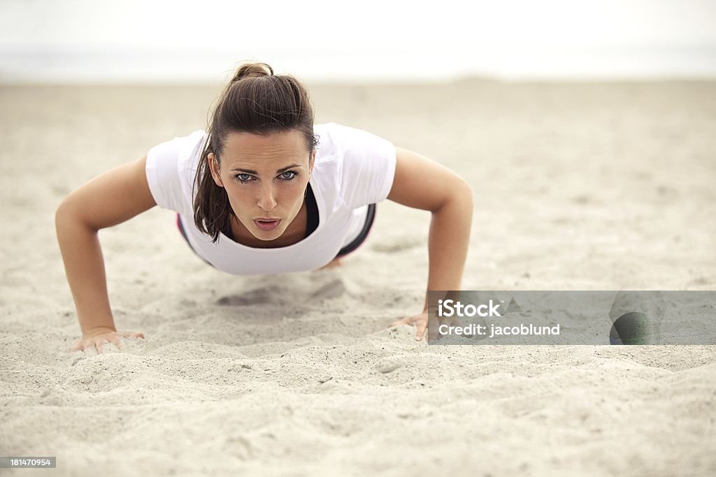 Atlética mulher fazendo flexão na praia - Foto de stock de 20-24 Anos royalty-free