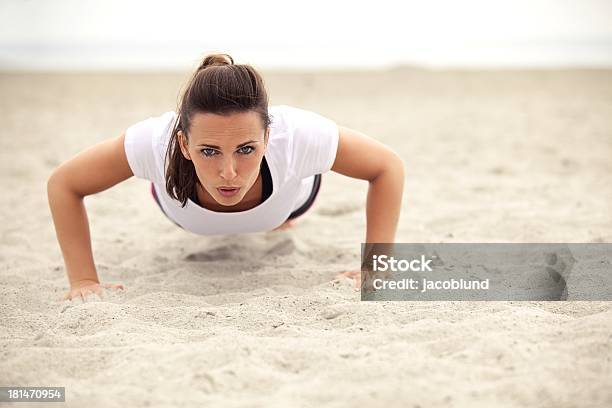 Foto de Atlética Mulher Fazendo Flexão Na Praia e mais fotos de stock de 20-24 Anos - 20-24 Anos, Adulto, Areia