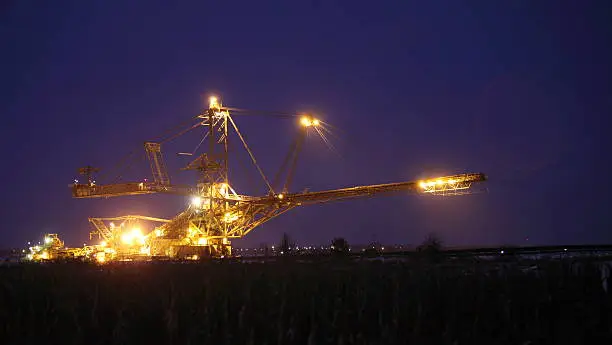 bucket wheel excavator digging for brown coal night view Poland extractive industry