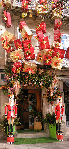 Christmas decorations over store front door, flowers and gifts, toy soldier figurines. Galicia, Spain.