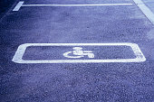 Disabled parking sign on the asphalt of a parking lot.