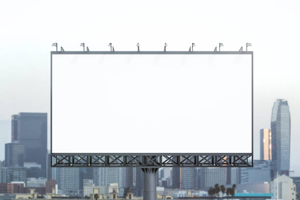 istock Blank white billboard on cityscape background at daytime, front view. Mock up, advertising concept 1814735972