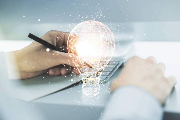 istock Creative light bulb illustration with hand writing in notepad on background with laptop, future technology concept. Multiexposure 1814737175