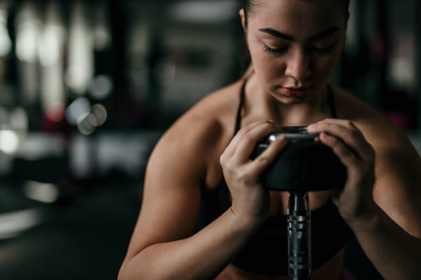istock Woman in gym lifting heavy weights. 1814741762