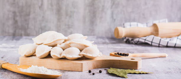 istock Homemade raw dumplings with meat on a cutting board on the table web banner 1814747867