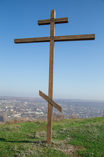 Wooden cross on blue sky. Whole background.