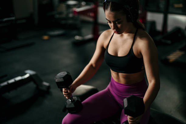 istock Woman in gym lifting heavy weights. 1814752147