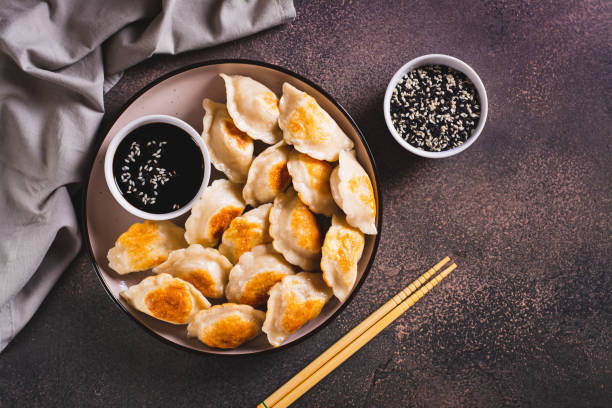 istock Pan-fried dumplings with soy sauce on a plate on the table top view 1814757843