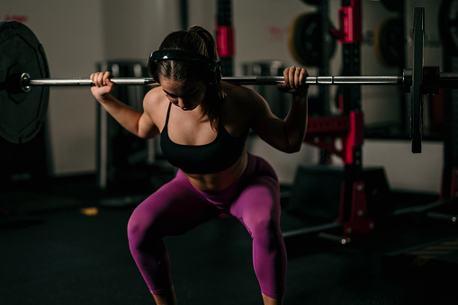 Woman in gym lifting heavy weights.