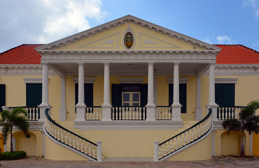Willemstad, Curaçao, Kingdom of the Netherlands: colonial neo-classical building of the Ministry of Finance (Ministero di Finansa / Ministerie van Financiën) - government of Curaçao - in 2010 when the dissolution of the Netherlands Antilles came into effect, Curaçao became a country within the Kingdom of the Netherlands, with the kingdom retaining responsibility for defence and foreign policy. The kingdom was also tasked with overseeing the island's finances under a debt-relief arrangement agreed upon between the two - Pietermaai. Unesco world heritage site.