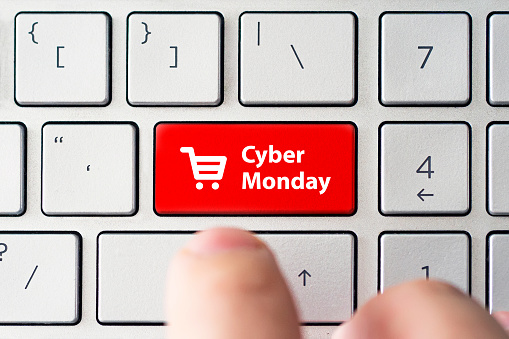 Cyber Monday and shopping trolley symbol on notebook gray keyboard. Online shopping at a discount. Sale day in the online store.