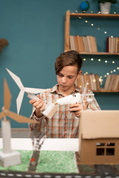 istock Smart young child work making wind turbines project at home. Boy learning about eco-friendly forms of renewable. 1814775077
