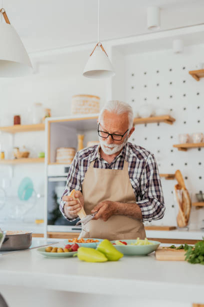 istock Senior man in kitchen cooking healthy meal 1814809653