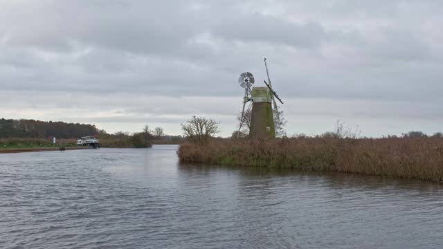 Abandoned and rundown windmill on the river bank