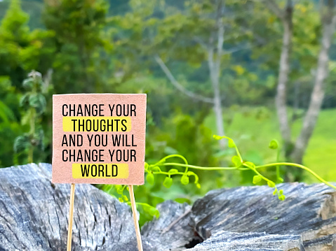 Inspirational Quote - Change your thoughts and you will change your world on placard with nature background.