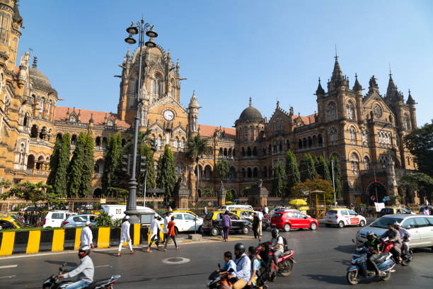 Chhatrapati Shivaji Maharaj Terminus 21st January, 2020 - Mumbai, India: This editorial image captures the daily hustle and bustle at the Chhatrapati Shivaji Maharaj Terminus (CST) Railway Station in Mumbai, one of India's most historic and busiest railway hubs. The station's stunning Victorian Gothic architecture, a UNESCO World Heritage Site, serves as a grand backdrop to the diverse array of people it attracts. The photograph includes railway workers in their uniforms, busy attending to their duties, commuters rushing to catch trains, and locals passing through the station's precincts. The image aims to depict the vital role of CST as a central node in Mumbai's transportation network, reflecting the dynamic pulse of the city and the blend of history and modernity that defines Mumbai's urban landscape. maharashtra stock pictures, royalty-free photos & images