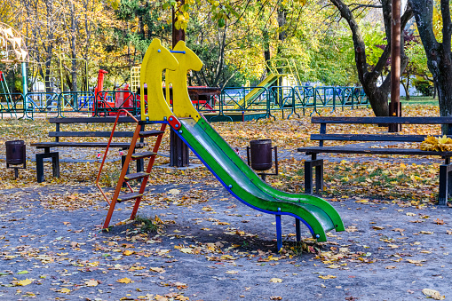 Slide at children playground at city park on autumn