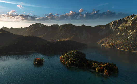 Mountain lake surrounded by forested mountains during autumn at sunrise. High angle view.