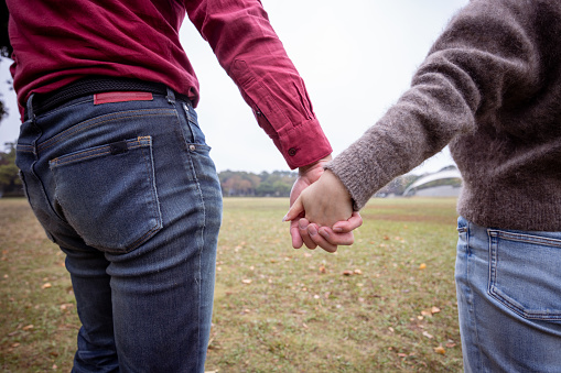 Couple holding hands in public park