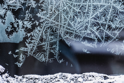 Decorative ice crystals on a window in form of a frame on black matte background